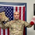 soldier holding stocking and other items sent by the desert angels